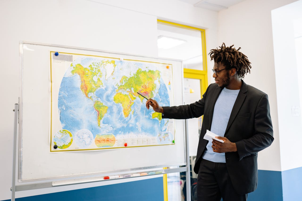 The Art of Drawing Readers In: Your attractive post title goes here Teacher pointing at world map during classroom lesson, engaging students.